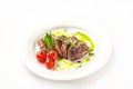 Chateaubriand in a restaurant close-up. Beef tenderloin steak with tomatoes on a white plate and copy space Royalty Free Stock Photo