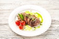 Chateaubriand in a restaurant close-up. Beef tenderloin steak with tomatoes on a white plate and copy space Royalty Free Stock Photo