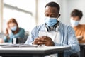 Black student with protective face mask using smartphone Royalty Free Stock Photo