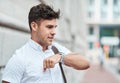 Chatting on a smartwatch with a young creative business man or intern commuting in the city. Hailing a cab, taxi or ride Royalty Free Stock Photo