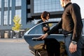 Chauffeur helps an elegant business woman gets in car Royalty Free Stock Photo