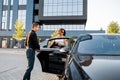 Chauffeur helps an elegant business woman gets in car Royalty Free Stock Photo