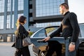 Chauffeur helps an elegant business woman gets in car Royalty Free Stock Photo