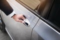 Chauffeur s hand on handle. Close-up of man in formal wear opening a passenger car door Royalty Free Stock Photo