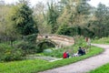 Chaveywell Bridge over the Wilts and Berks Canal with people sitting on the grassy bank