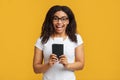 Cheap flights. Overjoyed black lady holding passport and tickets, standing over yellow background Royalty Free Stock Photo