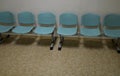 Cheap plastic chairs in a row by the wall. classic waiting room at the train station or at the doctor`s. corridor with washable su