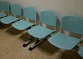 Cheap plastic chairs in a row by the wall. classic waiting room at the train station or at the doctor`s. corridor with washable su