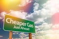 Cheaper Gas Green Road Sign Against Cloudy Sky Royalty Free Stock Photo