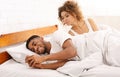 Cheating african man chatting with mistriss in family bed Royalty Free Stock Photo