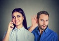 A cheating girlfriend. Curious man secretly listening to a happy woman talking on mobile phone with her lover Royalty Free Stock Photo