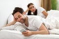 Cheating Husband Texting On Phone Ignoring Wife Lying In Bed