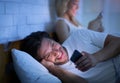 Cheating Husband Texting On Phone Lying With Wife In Bedroom