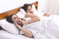 Cheating woman talking privately on cellphone in family bed Royalty Free Stock Photo