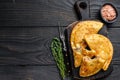 Cheburek meat pastry pie with herbs. Black wooden background. Top view. Copy space