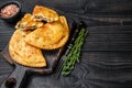 Cheburek meat pastry pie with herbs. Black wooden background. Top view. Copy space