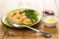 Chebureks with parsley and dill in plate, bowl with ketchup