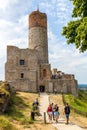 Tourists in front of Prison Tower and Eastern Gate of Checiny Royal Castle medieval fortress in Swietokrzyskie Mountains near