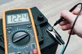 Check and charge car battery with charger. Auto mechanic measures voltage. Voltmeter to check voltage level on car battery. Car Royalty Free Stock Photo