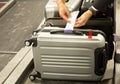 Check-in employee attaches a luggage tag to suitcase of passenger Royalty Free Stock Photo