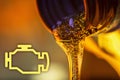 Check engine lamp and liquid stream of motorcycle motor oil flows from the neck of the bottle close-up. Royalty Free Stock Photo