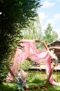 Check-in in the forest by the lake.A diamond-shaped arch of wood decorated with pampas, pink chiffon. Wedding floristry.