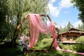 Check-in in the forest by the lake.A diamond-shaped arch of wood decorated with pampas, pink chiffon. Wedding floristry.