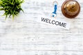 Check in at the hotel. Word welcome near service bell on light wooden table background top view copyspace