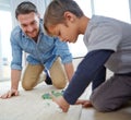 Check this move, Dad. a happy father and son playing marbles together at home. Royalty Free Stock Photo