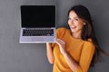 Check out this cool website. Portrait of an attractive young woman holding up a laptop with a blank screen. Royalty Free Stock Photo