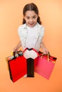 Check out her profitable purchases. Girl carries shopping bags yellow background. Girl fond of shopping. Child cute Royalty Free Stock Photo