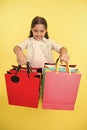 Check out her shopping packages. Girl carries shopping bags yellow background. Girl fond of shopping. Child cute Royalty Free Stock Photo