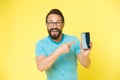 Check out new app. Guy eyeglasses cheerful pointing at smartphone. Man happy user recommends try application for Royalty Free Stock Photo