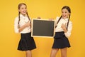 Check this out. School girls cute pupils hold blackboard copy space. Classmates initiative team yellow background. Join