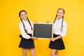 Check this out. School girls cute pupils hold blackboard copy space. School announcement concept. Classmates initiative