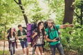 Check it out! Young excited tourists are walking in the spring canyon, having all needed for camping, talking, relaxing