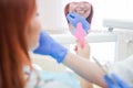 Check and select the color of the teeth in the dentist chair. Dentist makes the process of treating a beautiful young