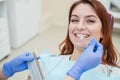 Check and select the color of the teeth in the dentist chair. Dentist makes the process of treating a beautiful young red-haired