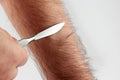 Check sharpness sharpening a scalpel on hair hands Royalty Free Stock Photo