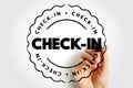 Check-In stamp with hand using marker, circular badge motif suggesting attendance, confirmation or entry process in a clean Royalty Free Stock Photo