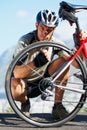 Check, wheel and man with bicycle on road, street and outdoor exercise with flat tire. Cycling, athlete and closeup on