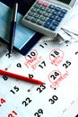 A checkbook, bills, a calculator and a calendar