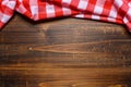 A checked gingham picnic tablecloth on old wooden table top view Royalty Free Stock Photo