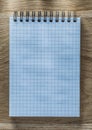 Checked spiral notebook pencil on wooden board directly above Royalty Free Stock Photo