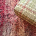 Checked textile hassock on a red carpet Royalty Free Stock Photo