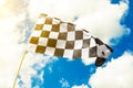 Checkered flag waving in the wind with sun flare seen Royalty Free Stock Photo