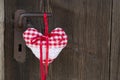 Checkered heart shape hanging on rusty door handle for valentine Royalty Free Stock Photo