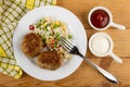 Napkin, fried cutlets with hawaiian blend, fork in plate, sauce boats with ketchup and mayonnaise on table. Top view Royalty Free Stock Photo