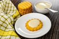 Napkin, stack of cookies, spoon in bowl with condensed milk,cookie poured condensed milk in saucer on wooden table Royalty Free Stock Photo