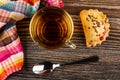 Napkin, transparent cup with tea, spoon, cookie with raspberry jam and linseeds on wooden table. Top view Royalty Free Stock Photo